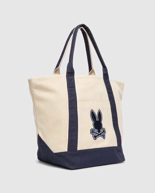 The Psycho Bunny MENS GRAPHIC TOTE - B6A563F200 is a canvas bag with navy accents and handles, featuring a black rabbit silhouette above crossbones on the front. It seamlessly blends style and utility with its simple, sturdy design against a light gray background, inspired by function-first hauler designs.