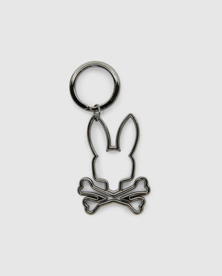 The Psycho Bunny OUTLINE BUNNY KEYCHAIN (B6A565E200) features a gold-plated design with a bunny head above crossed bones, providing a playful twist on the classic skull and crossbones—an eye-catching addition to any accessory collection.