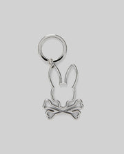 The Psycho Bunny MENS OUTLINE BUNNY KEYCHAIN (B6A565E200) is a durable silver accessory featuring a rabbit head over crossed bones, crafted from zinc alloy and set on a plain gray background.