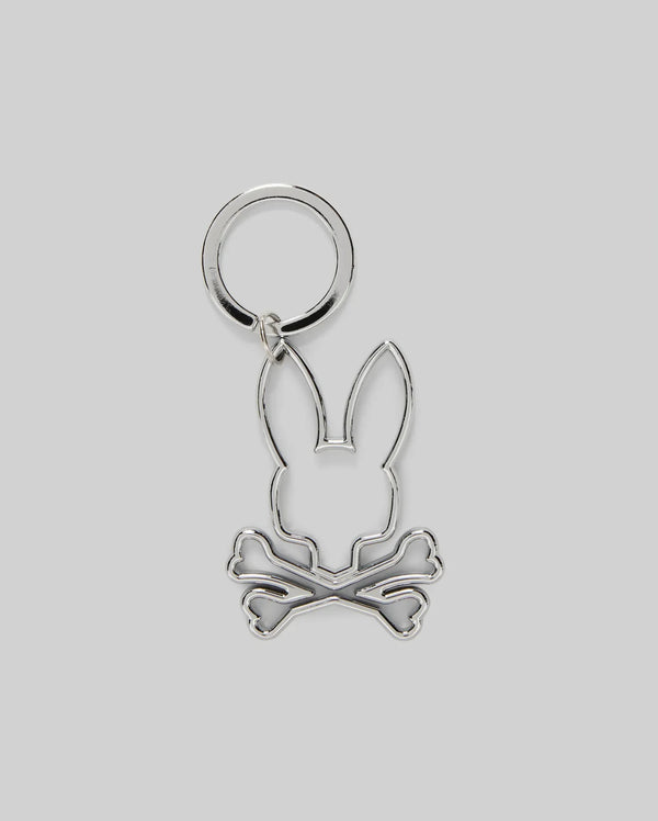 The Psycho Bunny MENS OUTLINE BUNNY KEYCHAIN (B6A565E200) is a durable silver accessory featuring a rabbit head over crossed bones, crafted from zinc alloy and set on a plain gray background.
