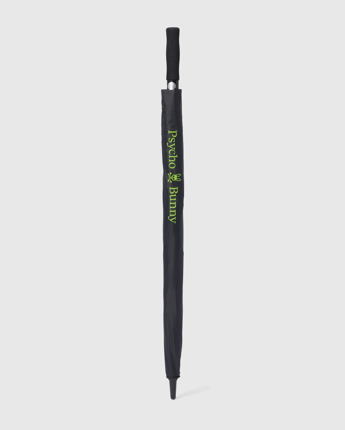 A black GOLF UMBRELLA - B6A624C200 with a protective cover. The cover features the text "Psycho Bunny" and a small bunny logo in green, vertically aligned along the length of this reliable umbrella. The handle is black with a grip texture. The umbrella is standing upright against a white background.
