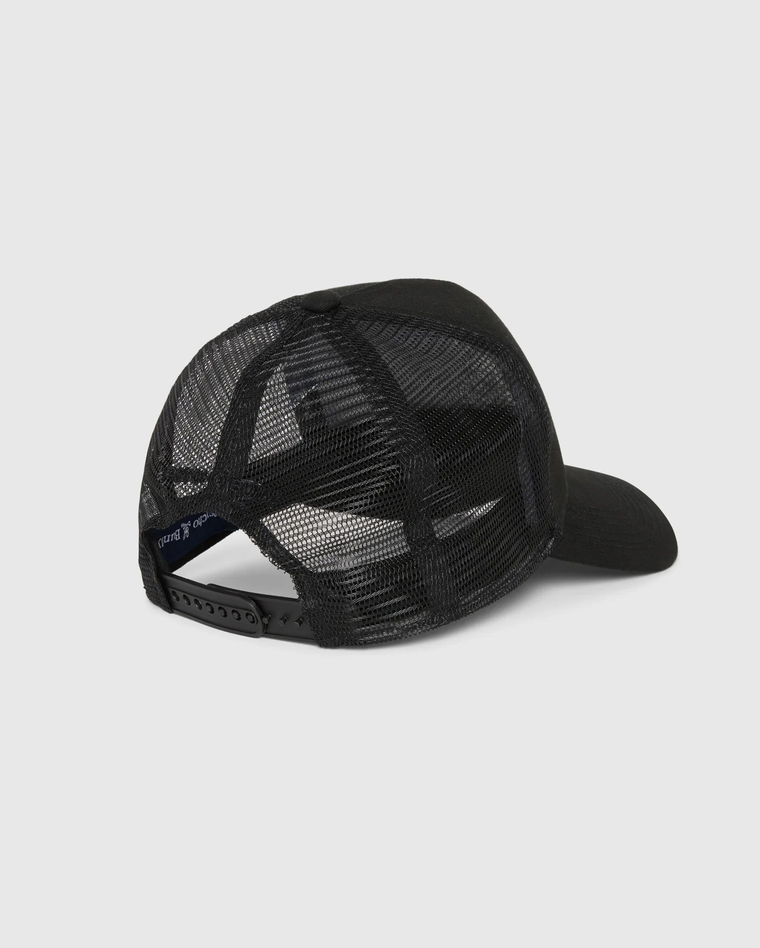 The MENS MALTON TRUCKER CAP by Psycho Bunny is showcased from the back, featuring a solid front panel, black mesh for breathability, and an adjustable snapback. The cap is set against a plain light gray background, perfect for casual style.