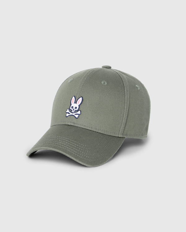 The Psycho Bunny Men's Classic Baseball Cap (B6A816B200) is a khaki green 100% cotton cap featuring an embroidered white bunny with crossed bones design, curved brim, and visible stitching against a plain light gray background.