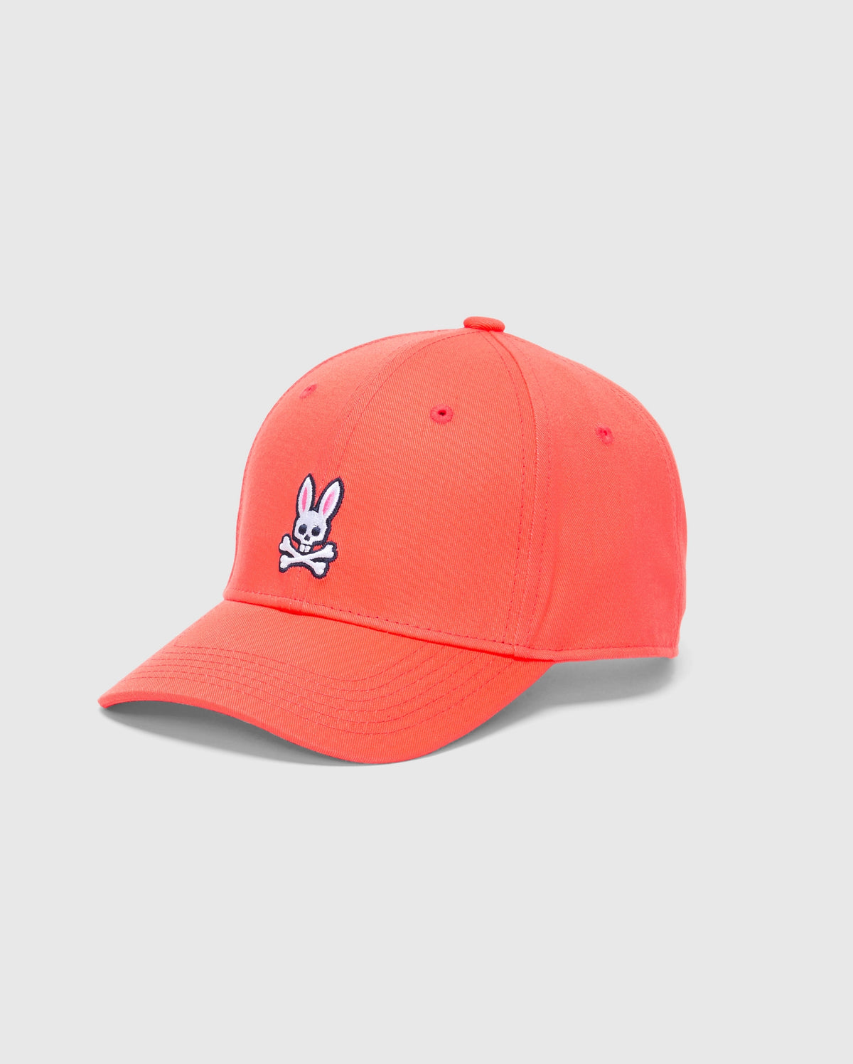 The Psycho Bunny MENS CLASSIC BASEBALL CAP - B6A816F200 is bright pink, made from cotton twill, and showcases a white bunny with crossed bones embroidered on the front. It features an adjustable fit and is set against a plain light gray background.