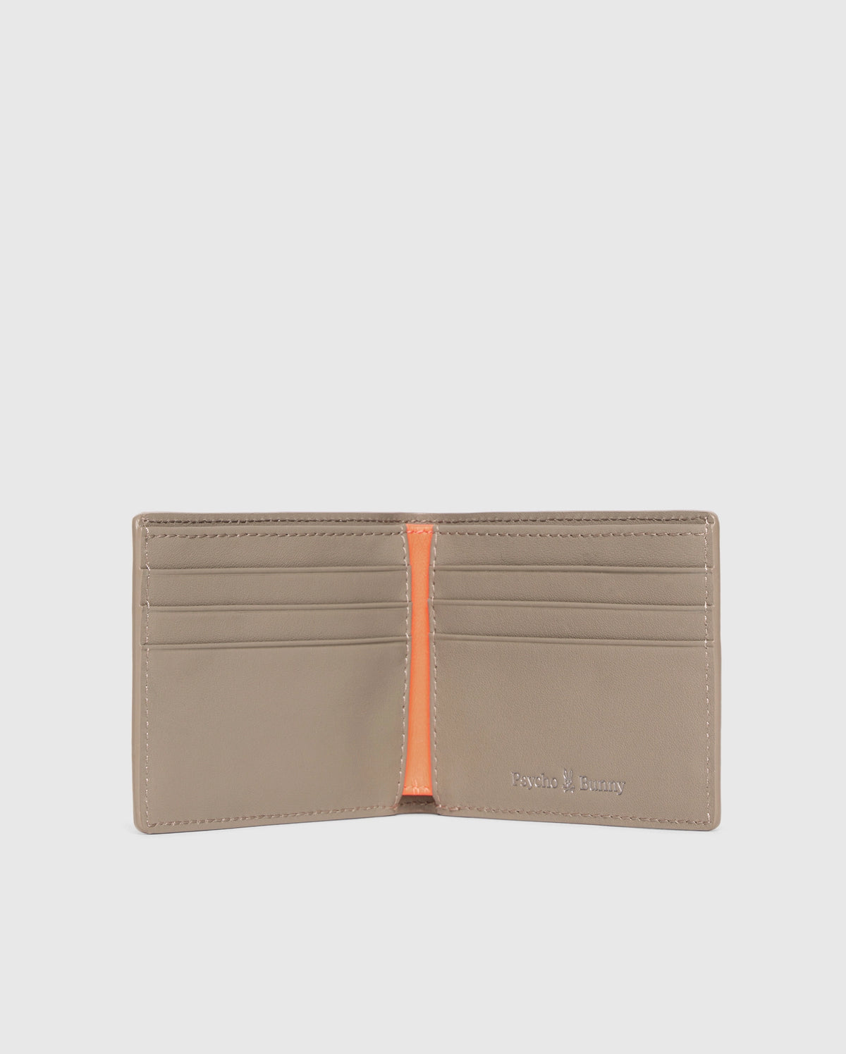 The MENS LEATHER WALLET - B6A868D200 by Psycho Bunny is open, showing six card slots with an orange center divider. The brand name is elegantly embossed in silver on the bottom right corner of this luxurious beige wallet's interior.