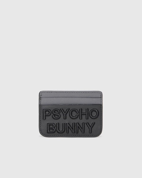 The Psycho Bunny MENS WORDMARK LEATHER CARD CASE (B6A869D200) is a black premium leather card holder with two slots and "PSYCHO BUNNY" embossed in large letters on the front, shown on a light gray background.
