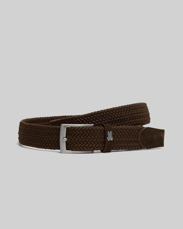 The Psycho Bunny MENS STRETCH BRAIDED BELT - B6A890F200 features a brown woven design, silver buckle, braided texture, and a small metallic emblem near the buckle, making it a stylish must-have accessory against a light gray background.
