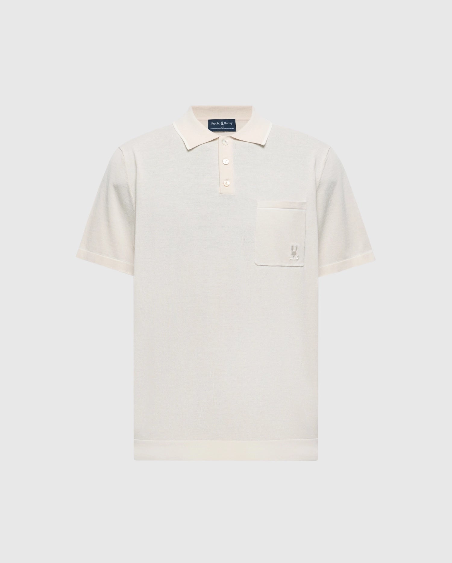 The Psycho Bunny MENS LONGFORD FINE KNIT POLO (B6E500F200) is a cream-colored cotton polo with short sleeves, a collar, three buttons, and an embroidered Bunny on the left chest pocket, shown on a light gray background.