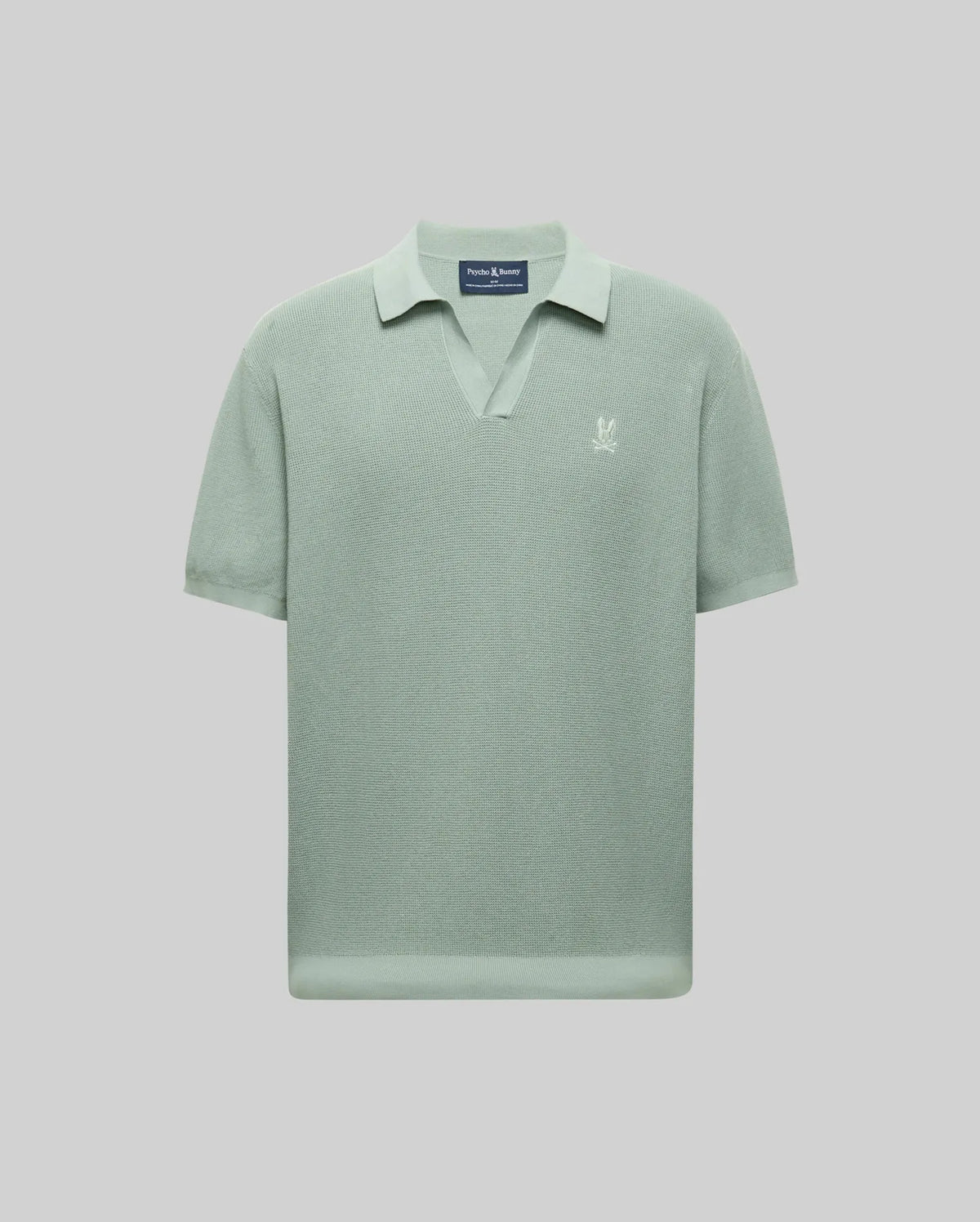 The Psycho Bunny MENS LEETON JOHNNY COLLAR KNIT POLO (B6E562F200) features light green short sleeves, a Johnny collar, and a small white embroidered Bunny logo on the left chest, shown on a plain light gray background.