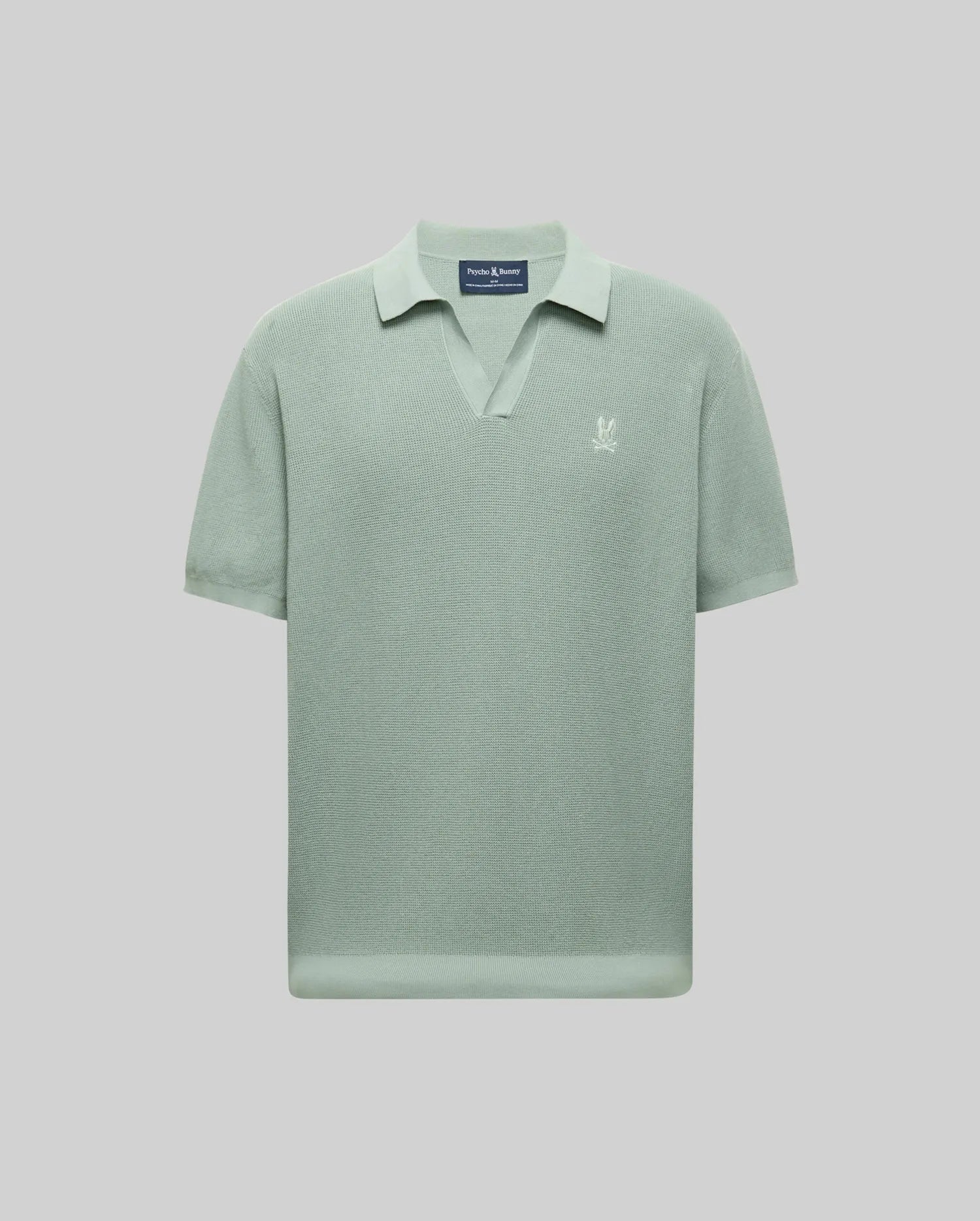The Psycho Bunny MENS LEETON JOHNNY COLLAR KNIT POLO (B6E562F200) features light green short sleeves, a Johnny collar, and a small white embroidered Bunny logo on the left chest, shown on a plain light gray background.