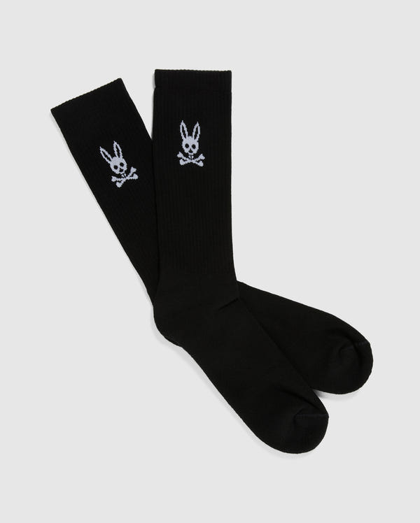 A pair of Psycho Bunny's MENS SPORT SOCK - B6F146X1PB, in black, made from soft Pima cotton features a white embroidered Bunny Logo of a rabbit skull and crossbones near the top. The socks are displayed flat on a plain white background.