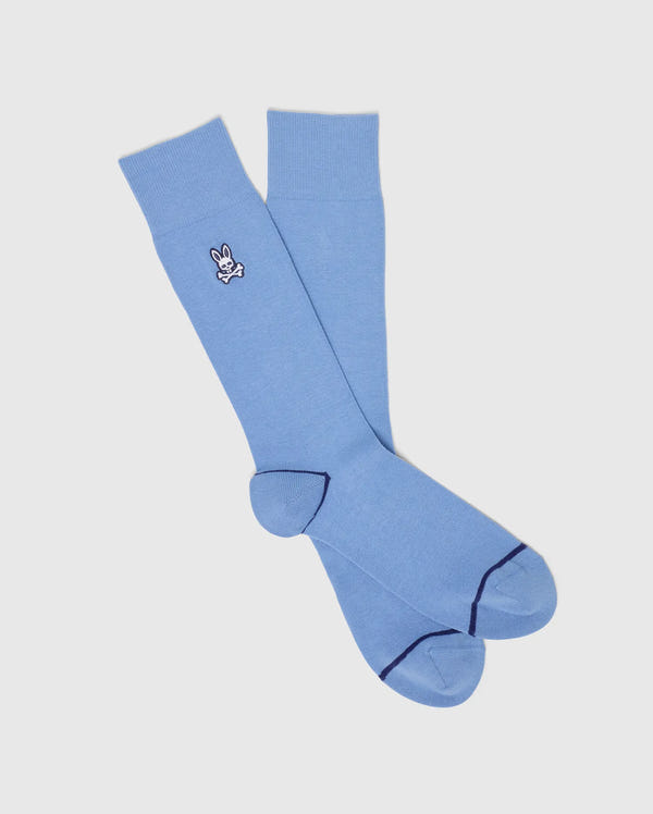 The Psycho Bunny MENS 3 PACK DRESS SOCK - B6F504F200 features light blue knee-high Pima cotton blend socks with a small white bunny logo near the top and dark blue accents on toe and heel, displayed on a white background.