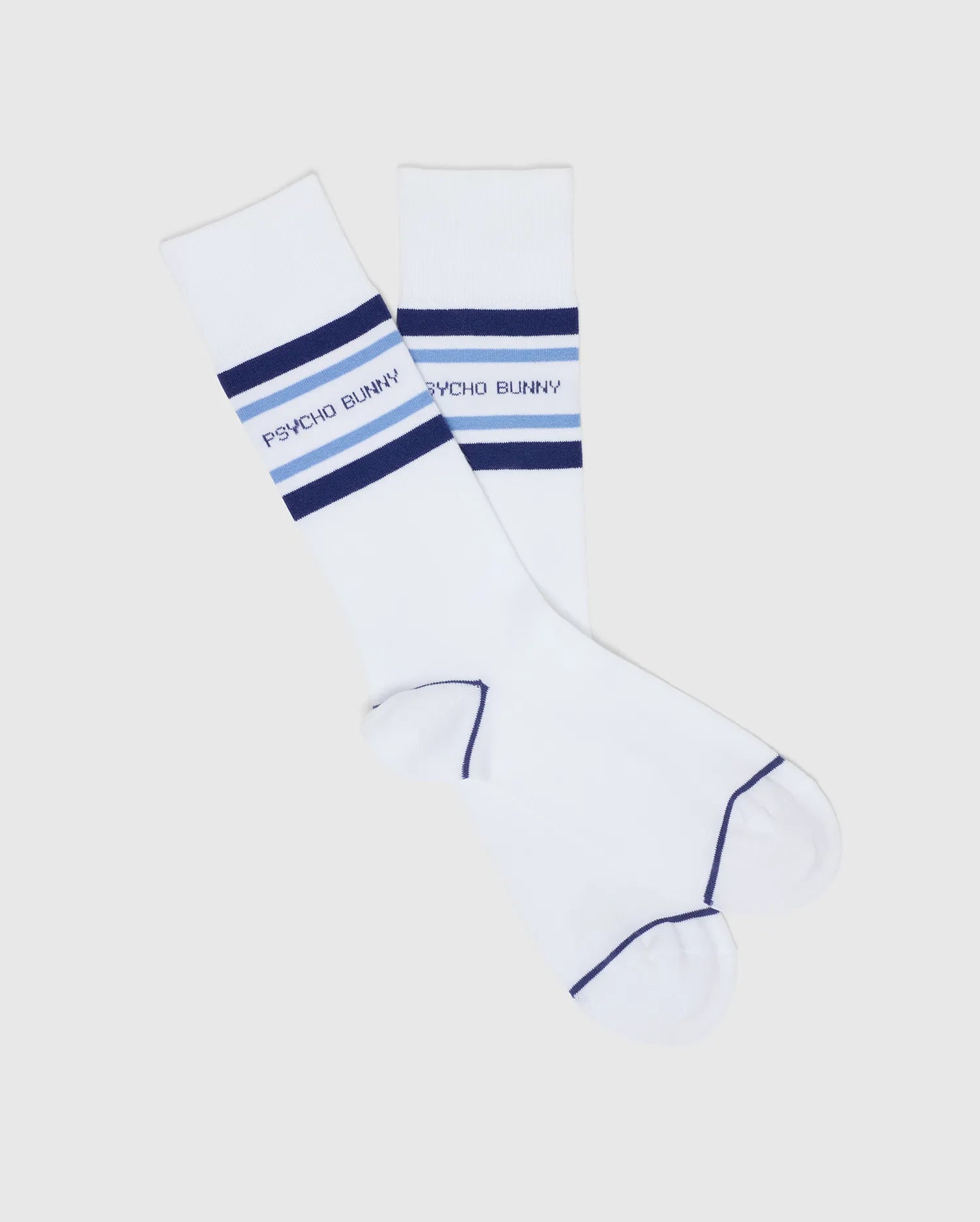 A pair of white Psycho Bunny MENS 3 PACK DRESS SOCK (B6F504F200) with blue stripes and "PSYCHO BUNNY" in blue across the top, crafted from soft Pima cotton blend, shown crossed on a plain light background.