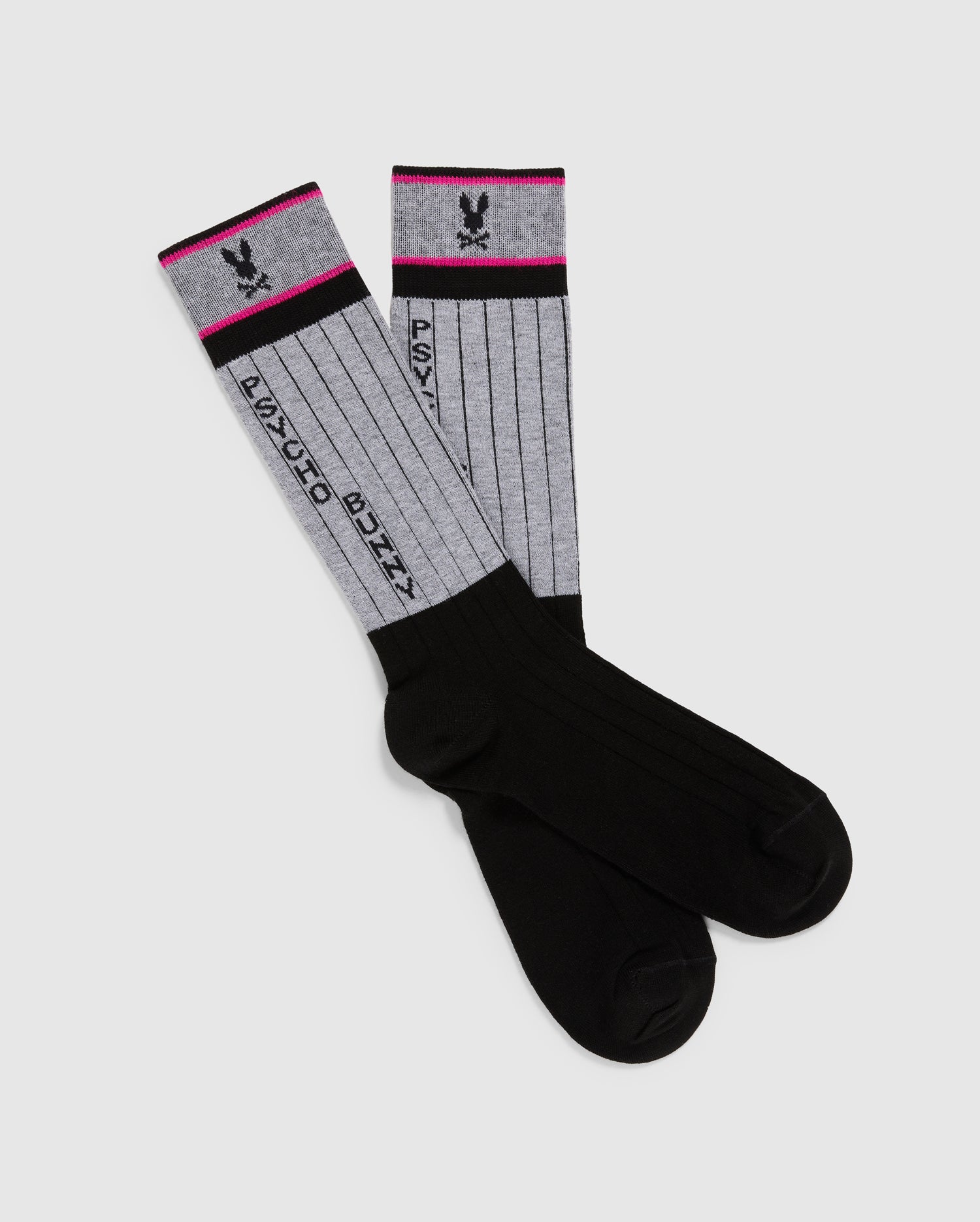 These black and gray knee-high dress socks feature vertical stripes, "PSYCHO BUNNY" text, and a small bunny logo in black and pink on the gray section. Crafted from soft Pima cotton, they have pink accents at the top edge. A stylish addition by Psycho Bunny: MENS CONTRAST COLOR DRESS SOCK - B6F760D200.