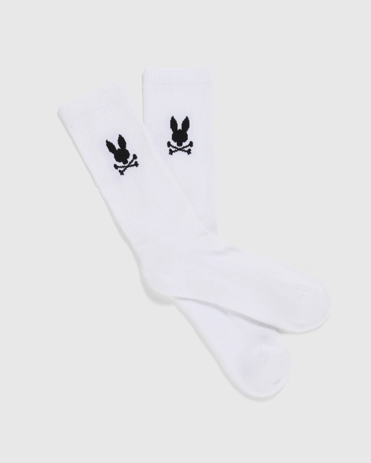 A set of 3 MENS 3 PACK SPORT SOCK - B6F997D200 by Psycho Bunny, showcasing a black skull and crossbones with bunny ears design near the top. These luxurious sport socks, crafted from Peruvian pima cotton, are displayed flat against a plain, light-gray background.