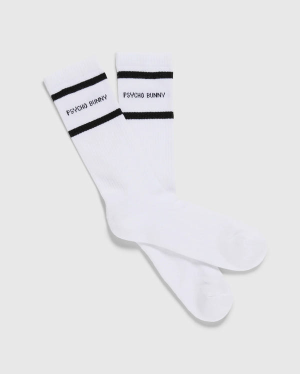 This pack includes three pairs of Psycho Bunny men's sport socks (MENS 3 PACK SPORT SOCK - B6F997D200), each featuring black stripes near the top and crafted from luxurious Peruvian Pima cotton. The phrase "PSYCHO BUNNY" is elegantly written in black between the two stripes, all showcased against a plain light grey background.