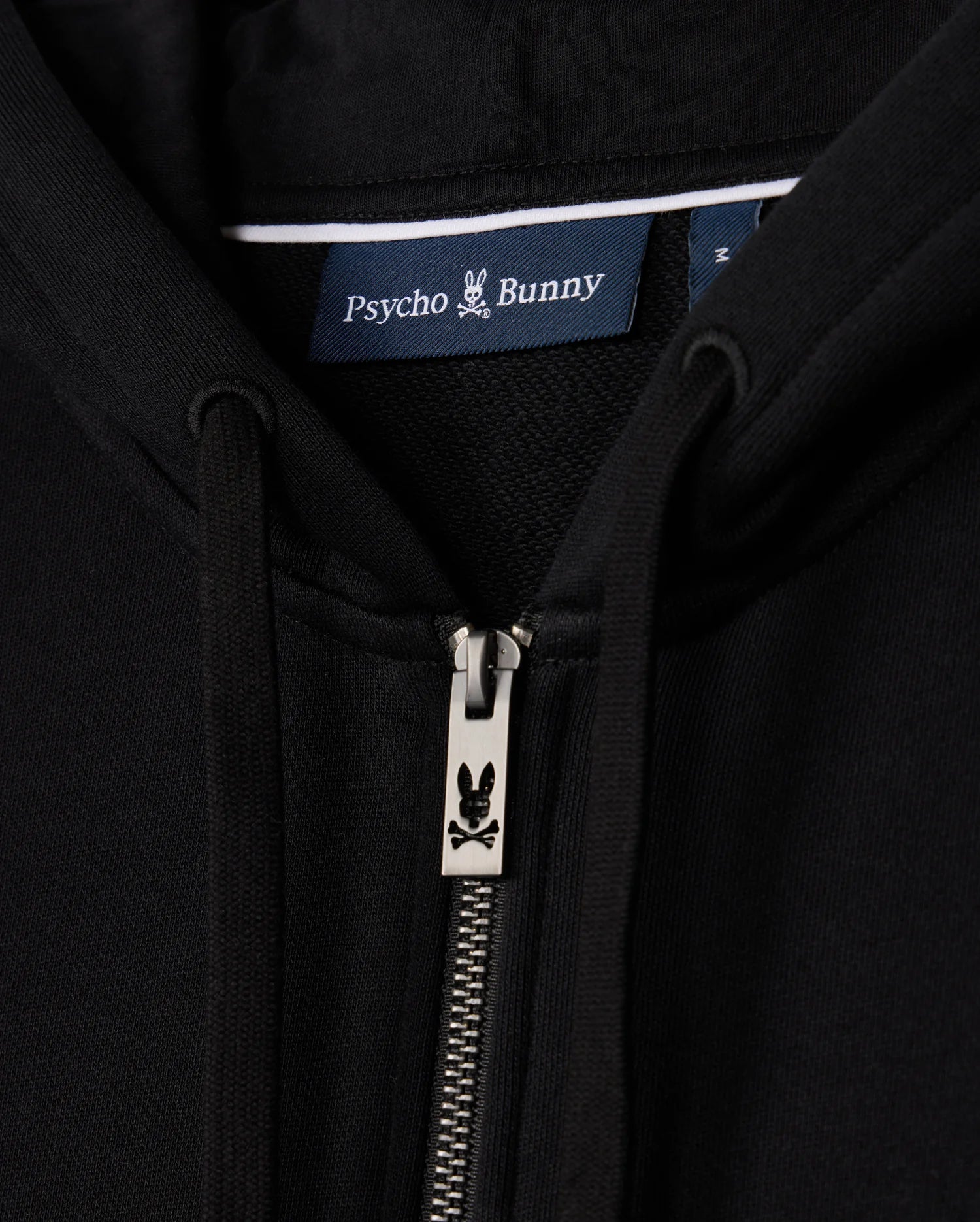 Close-up of the MENS LEVY ZIP FLEECE HOODIE - B6H720D200, focusing on a black cotton hoodie for men with a zipper featuring the iconic bunny logo and a "Psycho Bunny" label.