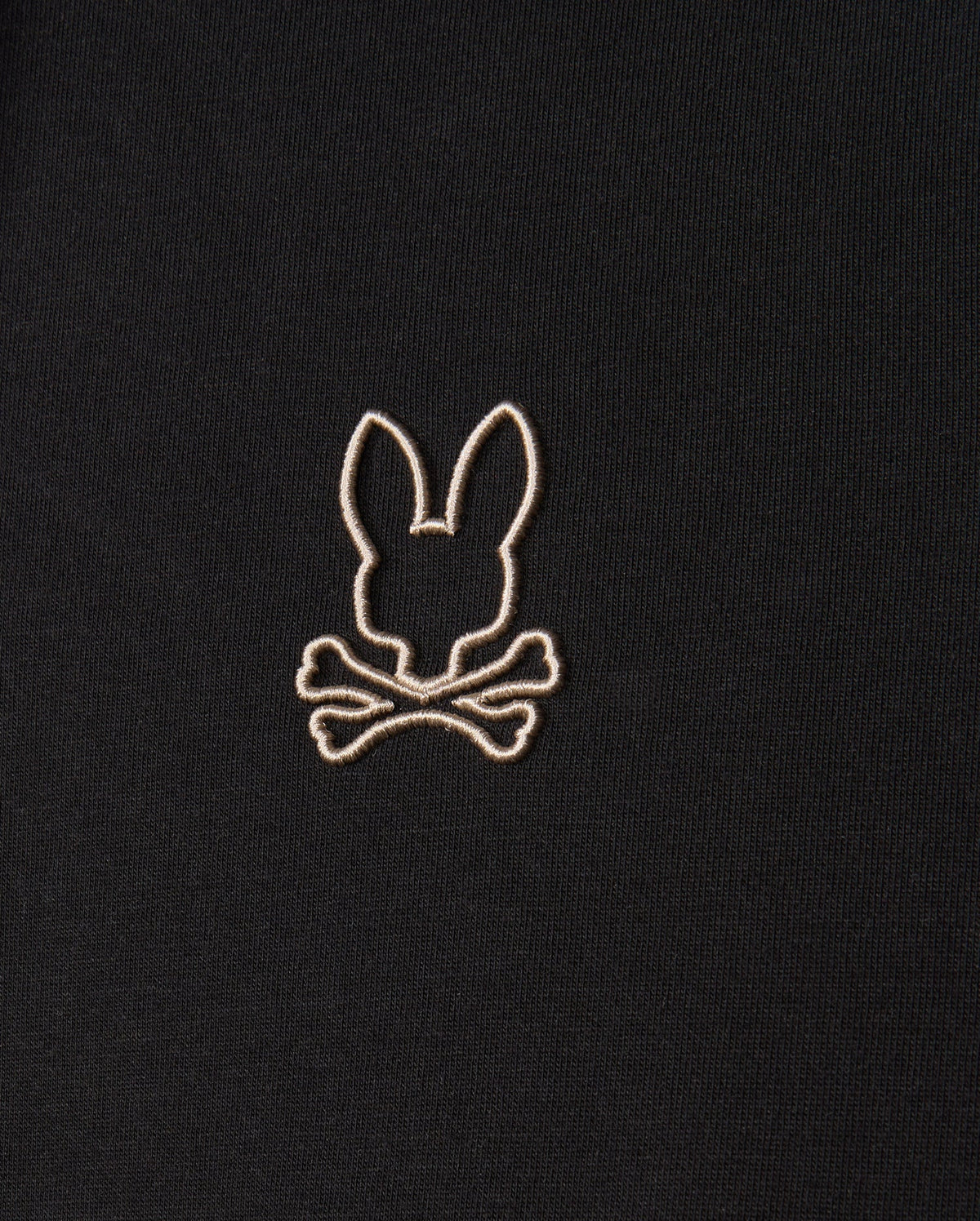 The Psycho Bunny MENS JAMES PREMIUM HOODIE - B6H789D200 features a black premium jersey fabric adorned with an embroidered design of a bunny head above two crossed bones in white stitching.