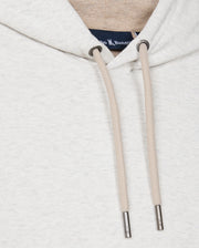 A close-up of the Psycho Bunny MENS JAMES PREMIUM HOODIE - B6H789D200 reveals a light gray essential fleece hoodie with beige drawstrings featuring metal tips. A small label with text is visible at the neckline inside the hoodie, highlighting its soft and fleecy fabric.
