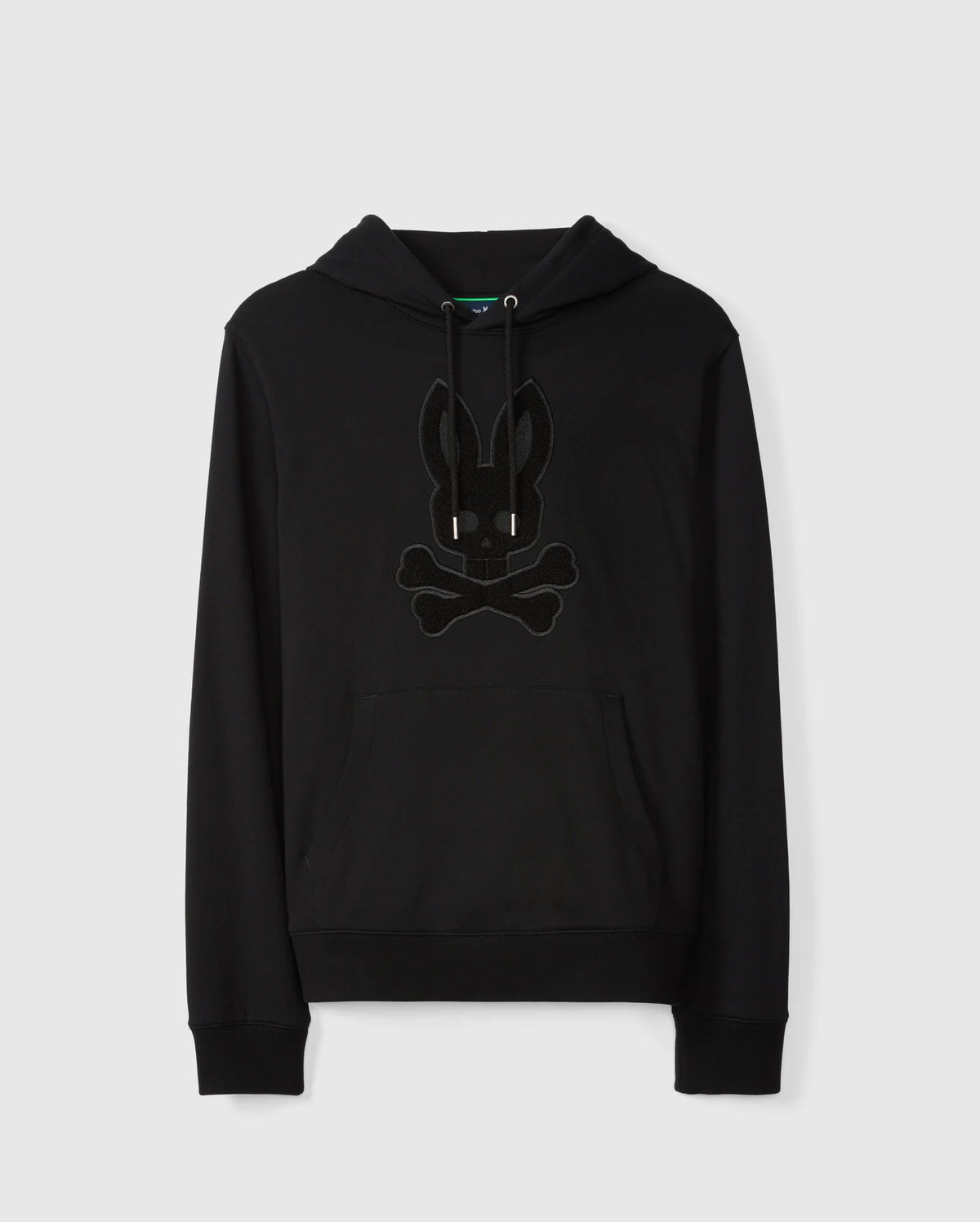 Introducing the MENS PACIFIC CHENILLE HOODIE - B6H930D200 by Psycho Bunny: A sleek black French terry hoodie made from 100% cotton, featuring a stylish front pocket and drawstrings. It sports a distinctive chenille embroidery patch of a bunny head with crossbones on the chest. Presented against a plain white background.