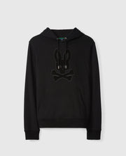Introducing the MENS PACIFIC CHENILLE HOODIE - B6H930D200 by Psycho Bunny: A sleek black French terry hoodie made from 100% cotton, featuring a stylish front pocket and drawstrings. It sports a distinctive chenille embroidery patch of a bunny head with crossbones on the chest. Presented against a plain white background.