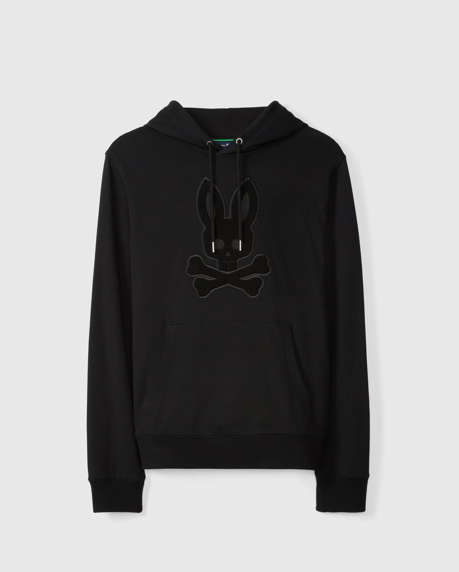 Introducing the MENS PACIFIC CHENILLE HOODIE - B6H930D200 by Psycho Bunny: A sleek black French terry hoodie made from 100% cotton, featuring a stylish front pocket and drawstrings. It sports a distinctive chenille embroidery patch of a bunny head with crossbones on the chest. Presented against a plain white background.