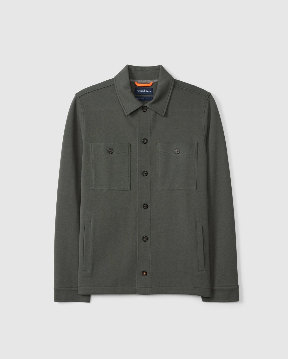 The MENS BEDFORD SHIRT JACKET B6J290B200 by Psycho Bunny is a dark green cotton-blend button-up with a collar and two chest pockets, adding an urban feel to any outfit against a plain white background.