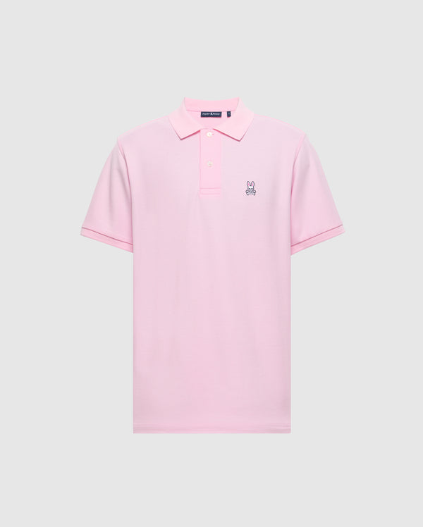 The Psycho Bunny Men's Classic Pique Polo Shirt (B6K001CRPC) is crafted from soft Peruvian pima cotton in light pink, with a collar, three buttons, and a small embroidered bunny logo on the left chest against a plain gray background.