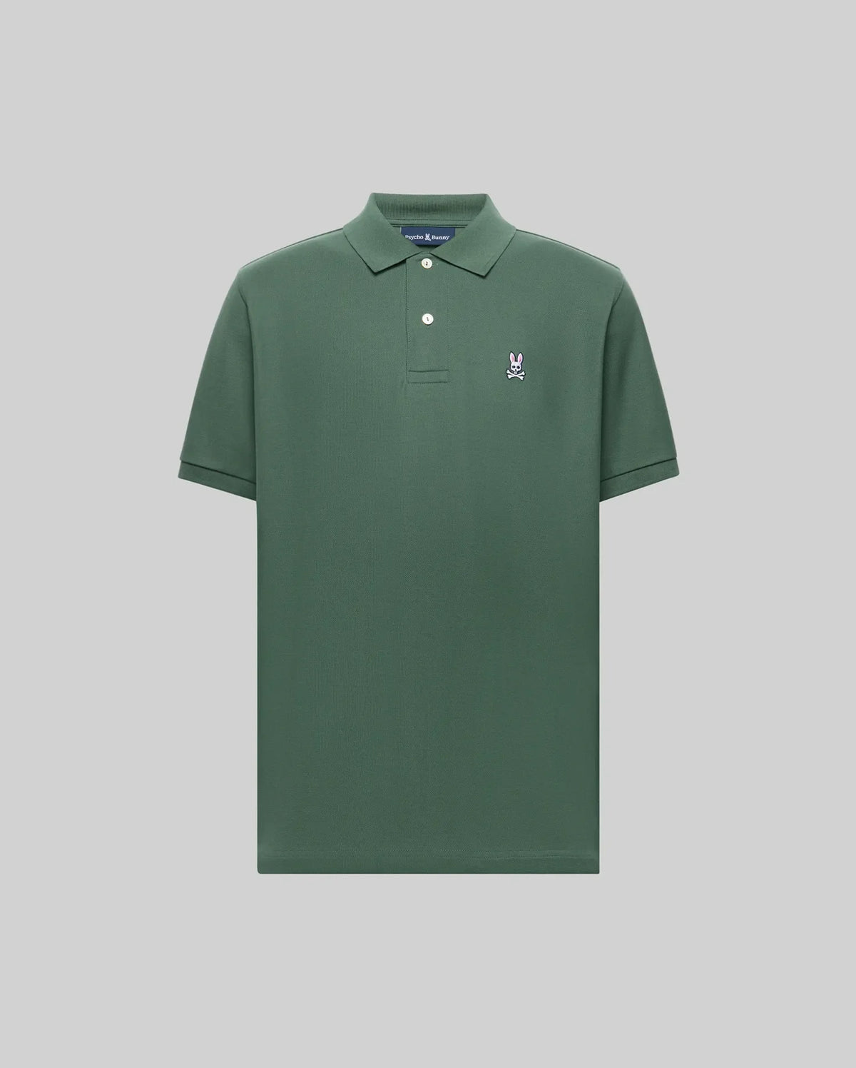 The Psycho Bunny MENS CLASSIC PIQUE POLO - B6K001F200 is a plain green men's polo in soft Pima cotton, with a collar, two buttons, and a small embroidered Bunny logo on the left chest, shown on a light gray background.