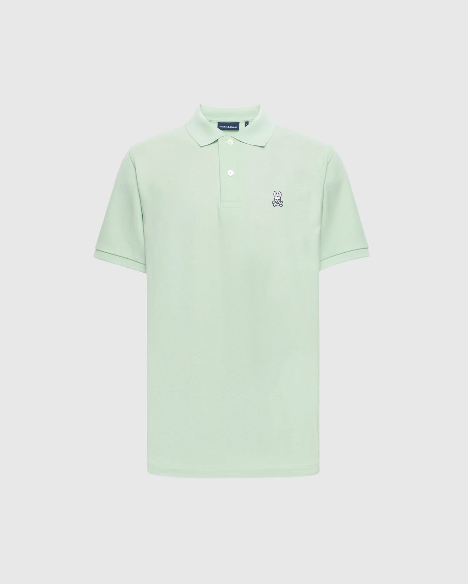 The Psycho Bunny Men's Classic Pique Polo (B6K001F200) in light green Pima cotton features a collar, short sleeves, and an embroidered Bunny logo with crossbones on the left chest against a plain white backdrop.