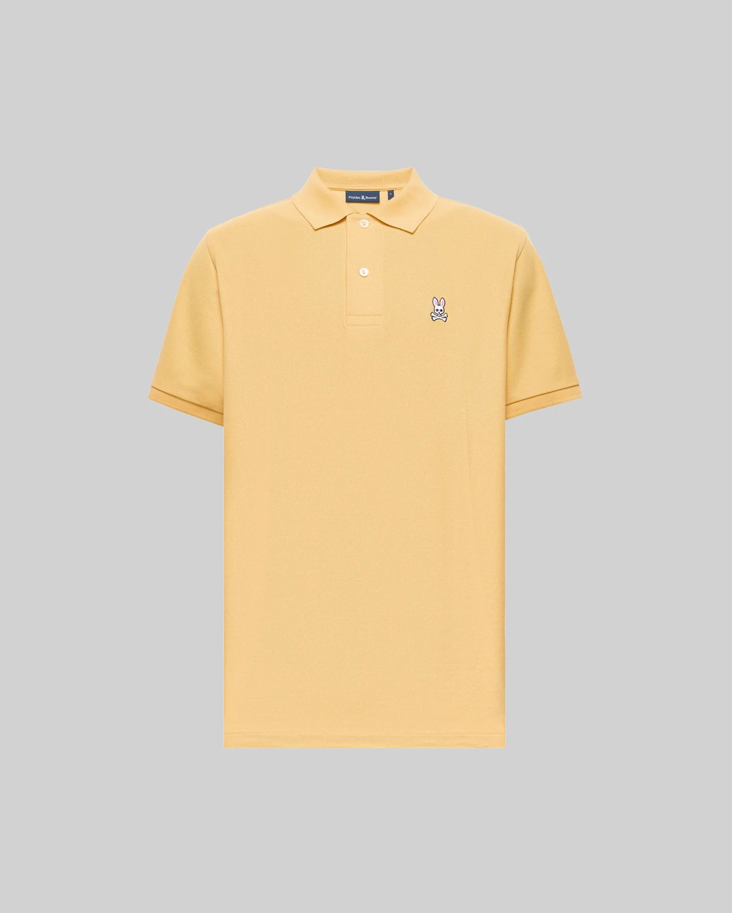 The Psycho Bunny MENS CLASSIC PIQUE POLO - B6K001F200 is a light yellow, short-sleeve Pima cotton polo with a collar, two buttons, and an embroidered Bunny logo on the left chest, set against a plain gray background.