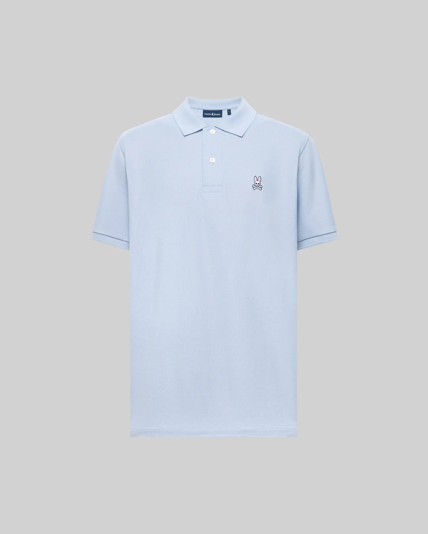 The Psycho Bunny MENS CLASSIC PIQUE POLO (B6K001F200) is a light blue short-sleeved Pima cotton men’s polo with a collar, two buttons, and an embroidered bunny logo on the left chest, shown on a plain gray background.