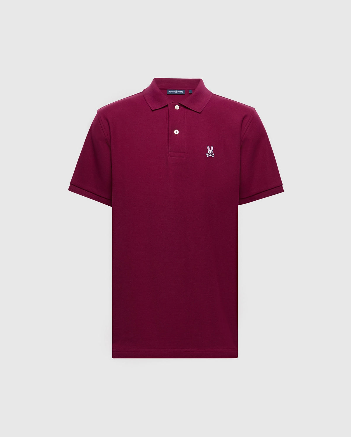 The Psycho Bunny Men's Classic Pique Polo Shirt - B6K001Z1PC features a maroon color crafted from soft Pima cotton, short sleeves, collar with two buttons, and a distinguished embroidered Bunny logo on the left chest on a plain light gray background.