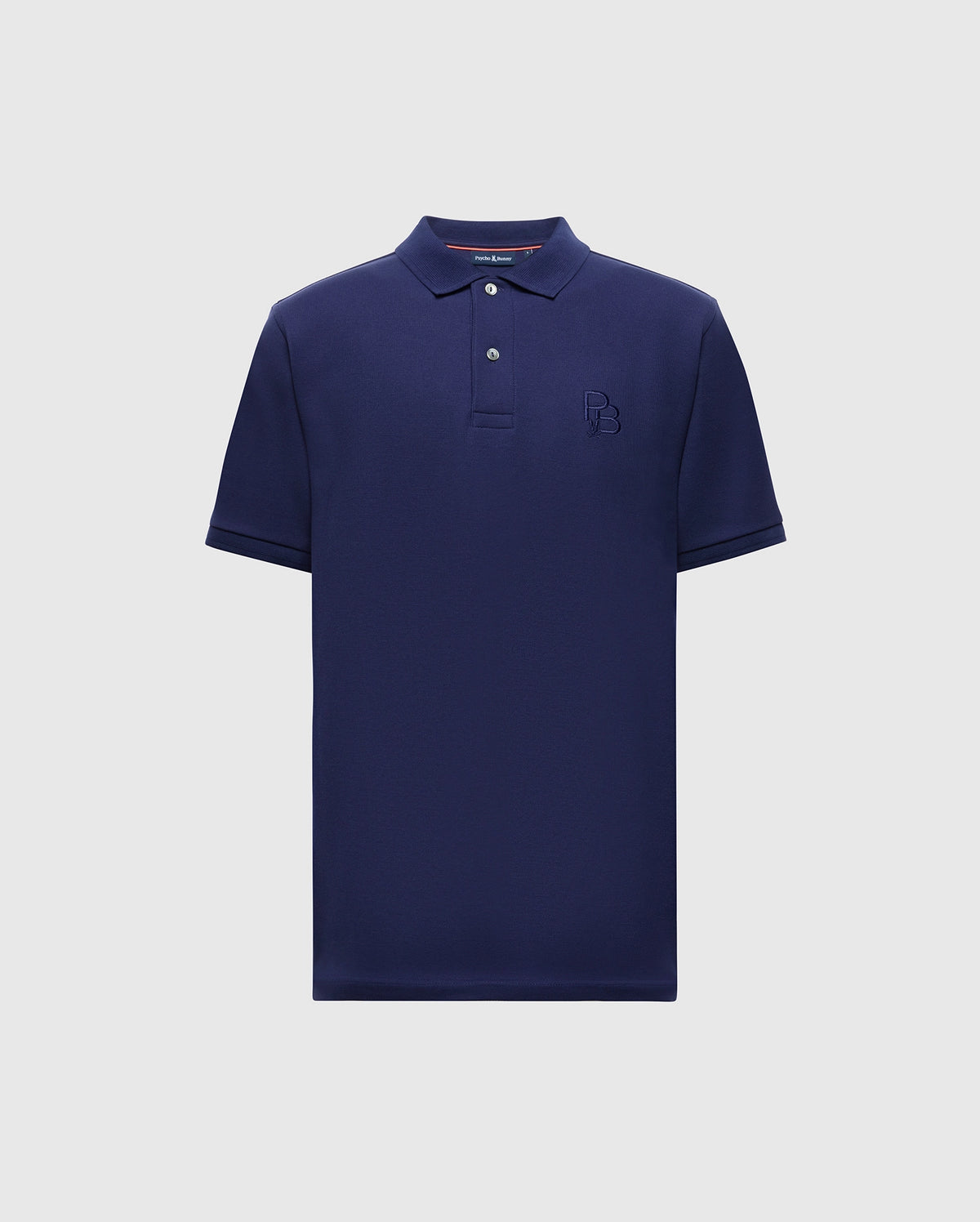 The Psycho Bunny MENS NICHOLSON RIB COLLAR PIQUE POLO - B6K401F200 is a navy blue shirt made from Pima cotton, featuring a classic collar, short sleeves, two buttons, and a subtle embroidered logo on the chest against a light gray background.