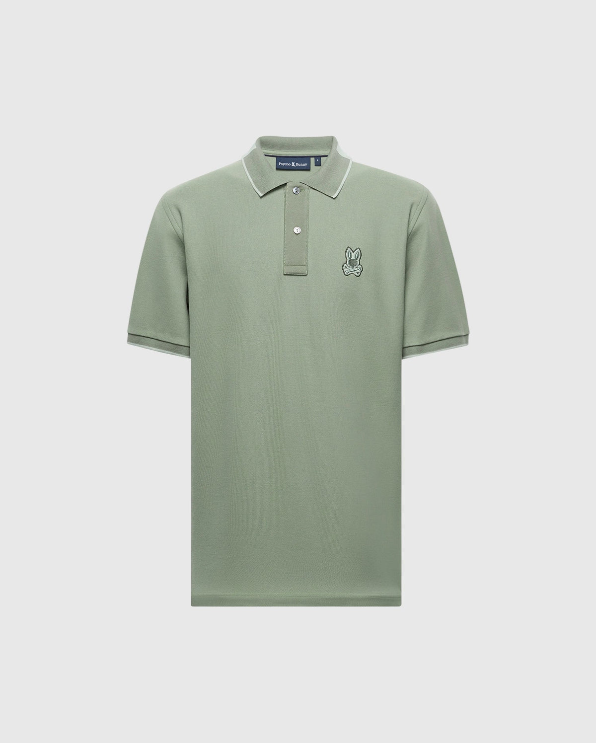Explore the Psycho Bunny MENS NEW CASTLE PIQUE POLO in light green with white trim on the collar and sleeves. Made from soft Pima Cotton, it has a small embroidered rabbit on the left chest and a classic button-up neckline, offering luxurious details against a pristine white backdrop.