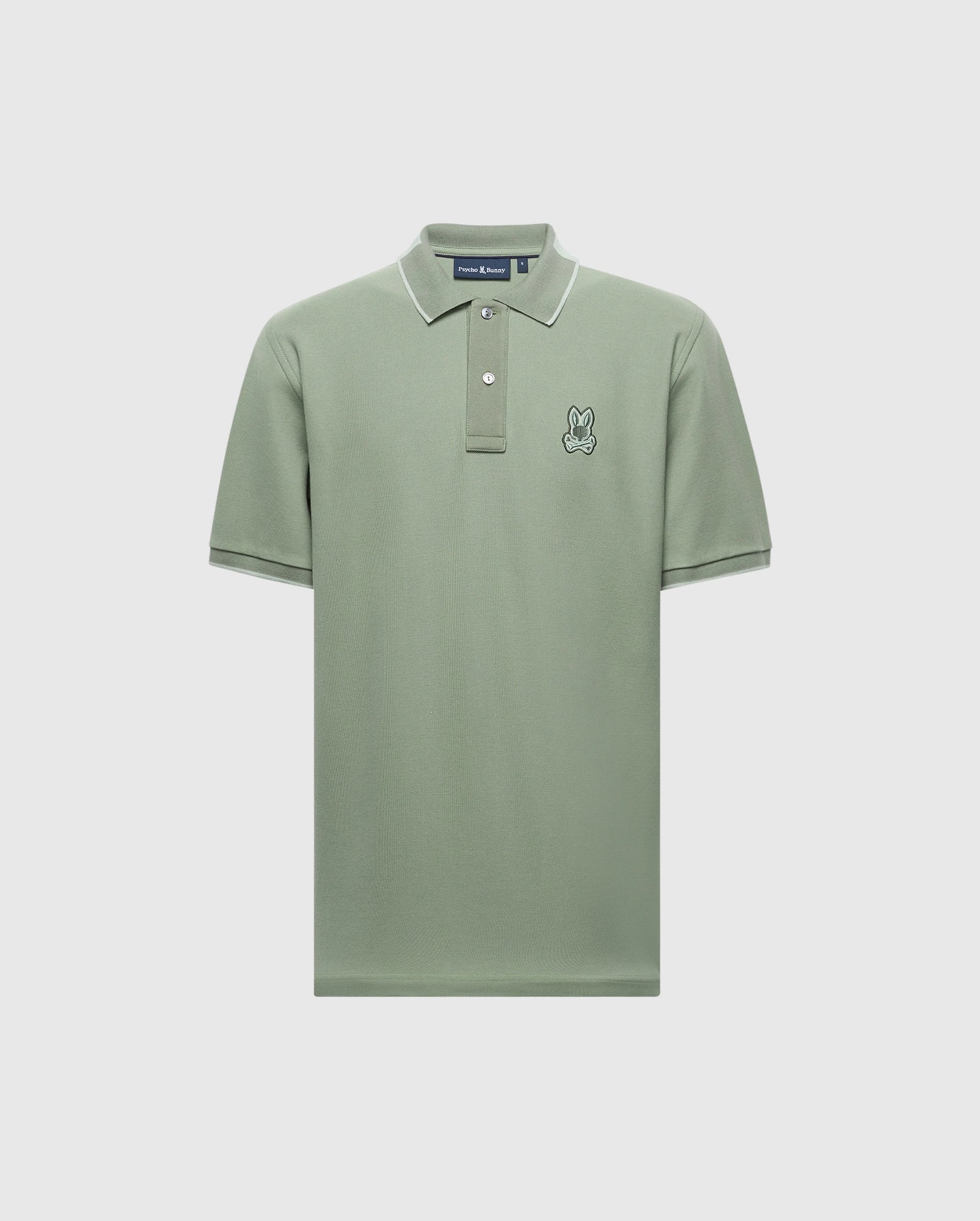 Explore the Psycho Bunny MENS NEW CASTLE PIQUE POLO in light green with white trim on the collar and sleeves. Made from soft Pima Cotton, it has a small embroidered rabbit on the left chest and a classic button-up neckline, offering luxurious details against a pristine white backdrop.