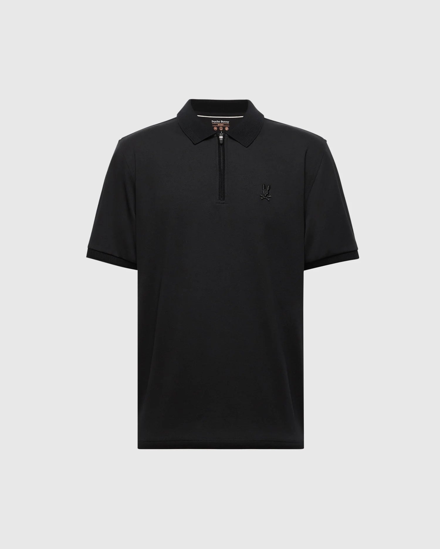 The Psycho Bunny MENS TREVOR PERFORMANCE PIQUE ZIP UP POLO (B6K557F200) is a black slim fit short-sleeve polo in soft Pima cotton, with a zip collar and small embroidered logo on the left chest, shown on a plain light gray background.