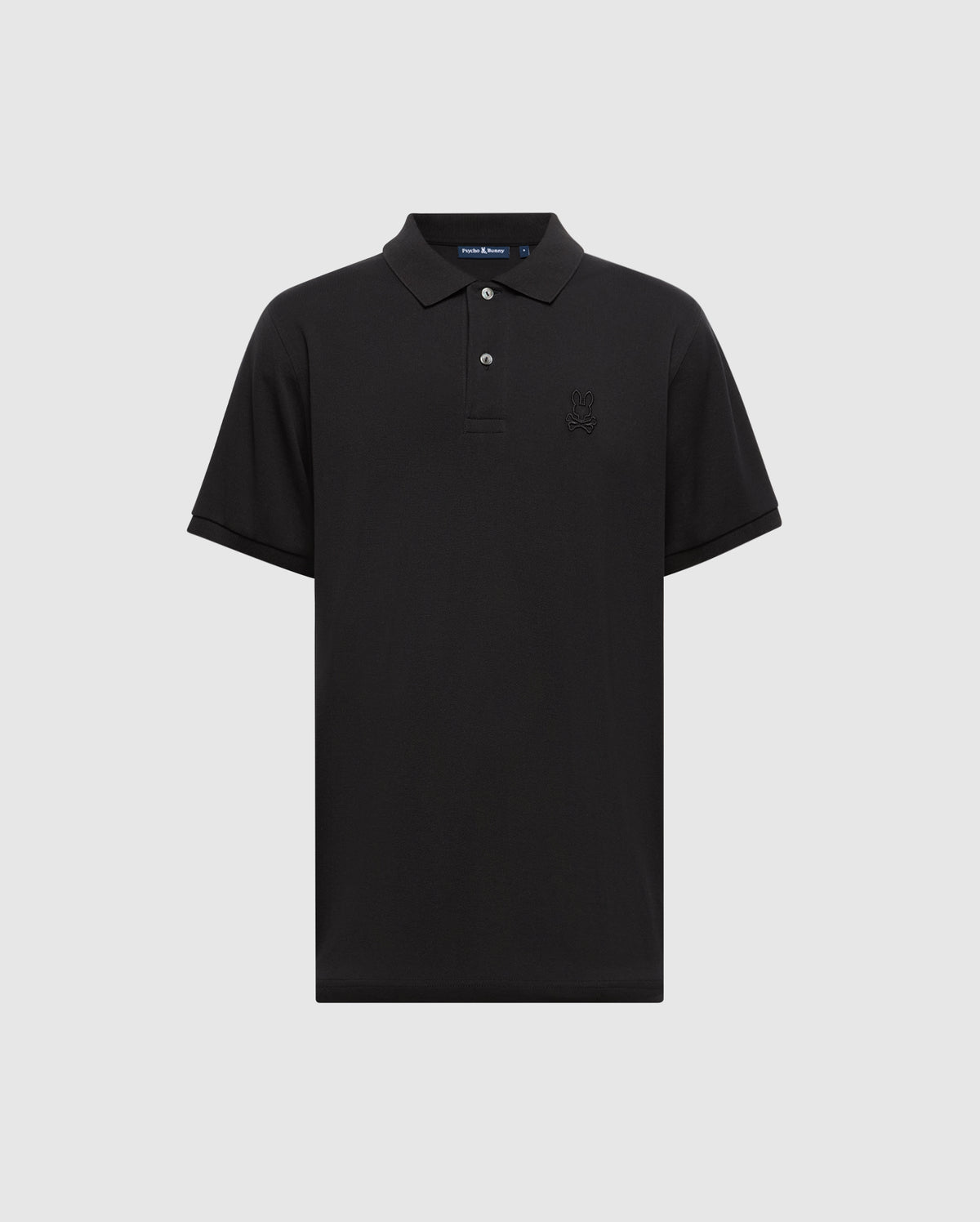 The Psycho Bunny MENS JAMES PREMIUM PIQUE POLO SHIRT - B6K945D200 is a lightweight black Pima cotton polo featuring short sleeves, a collar, a three-button placket, and a subtle embroidered logo on the left chest. It is showcased against a light gray background.