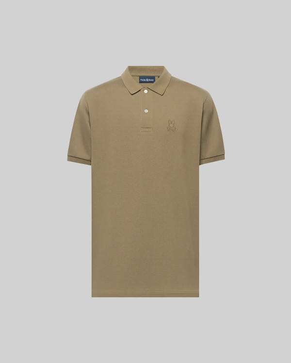 The Psycho Bunny MENS JAMES PIQUE POLO (B6K945D200) is a khaki short-sleeve Pima cotton polo with a collar, two white buttons, and an embroidered bunny logo on the left chest, shown against a plain light gray background.