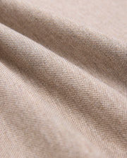 Close-up of beige Pima cotton fabric showcasing its fine weave and texture. The material is slightly draped, forming gentle folds that highlight its softness and quality, making it look ideal for crafting a durable Psycho Bunny MENS JAMES PREMIUM PIQUE POLO SHIRT - B6K945D200.