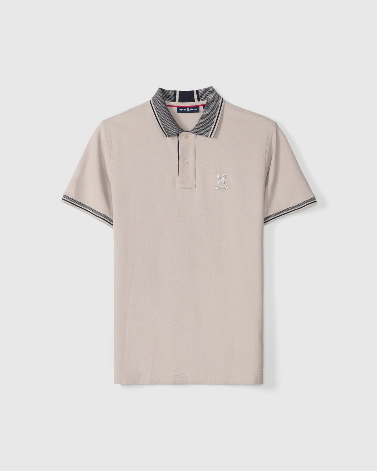 The Psycho Bunny Men's Malton Pique Polo Shirt (B6K950D200) is made from light beige Pima cotton and features a stylish gray collar and sleeve cuffs. It includes a sleek, buttoned placket, sporty trim details, and an embroidered Psycho Bunny logo on the left chest.