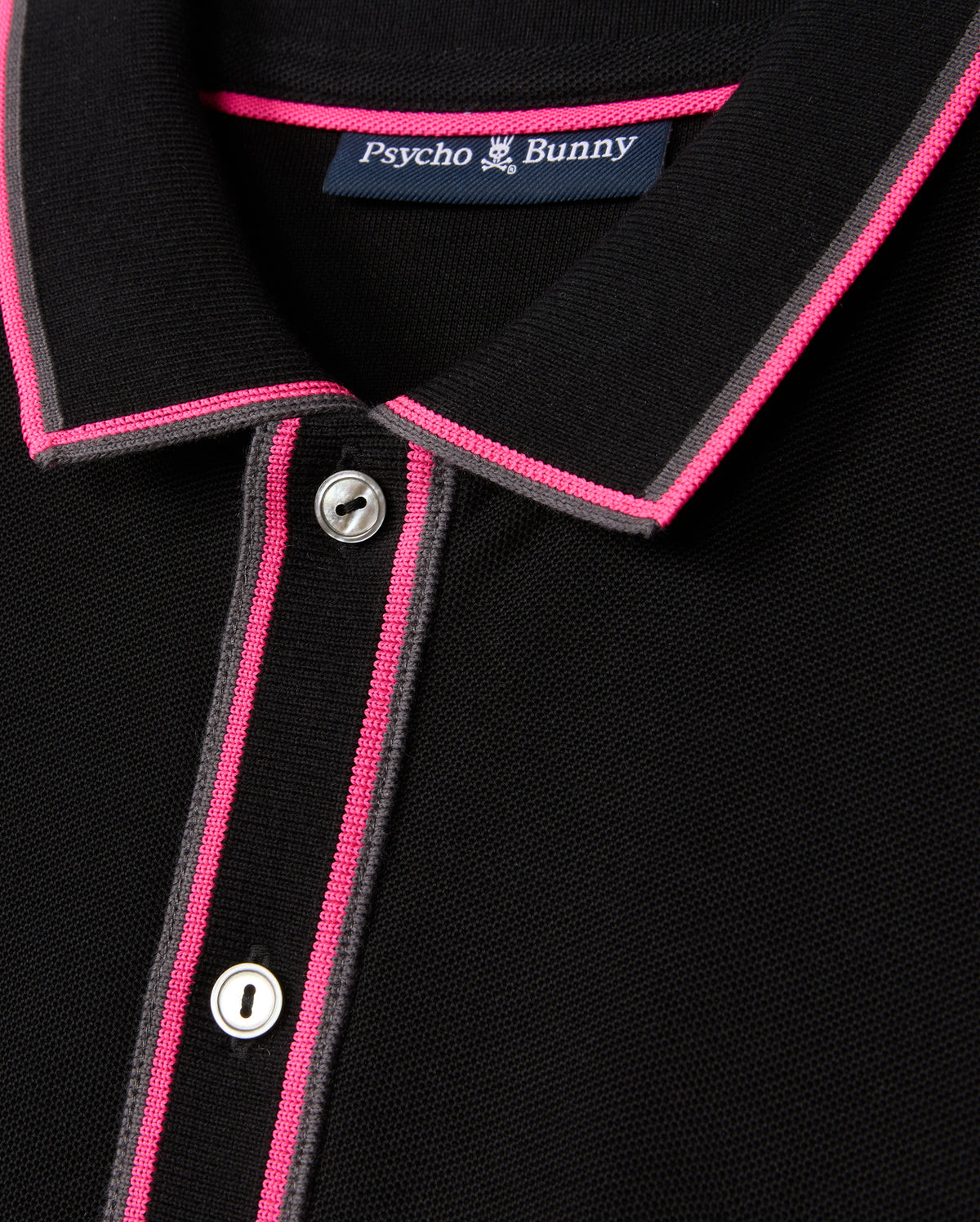 Close-up of the MENS KENT PIQUE POLO SHIRT - B6K951D200, showcasing a chic black design with pink and gray accents on the collar and button placket. Featuring two visible buttons and an interior "Psycho Bunny" label, this shirt is crafted from comfortable pique fabric, ideal for those who value fashion-forward elegance.