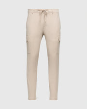 The MENS LLOYD CARGO JOGGER - B6P159B200 by Psycho Bunny is a pair of slim-fit beige cargo jogger pants, featuring tapered legs, an elastic waistband with a drawstring, two side pockets, and two cargo pockets on the thighs. These joggers are adorned with a subtle silicone branded detail.