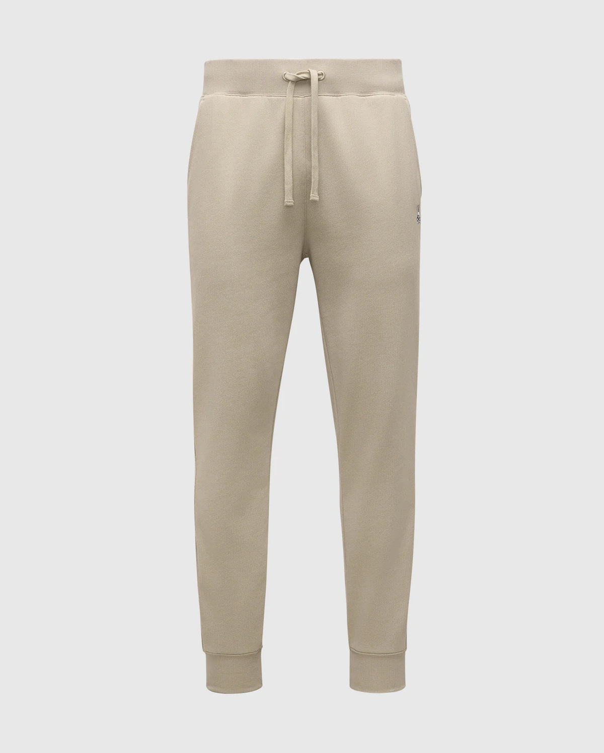 The MENS LEVY ESSENTIAL FLEECE SWEATPANTS - B6P721D200 by Psycho Bunny are beige sweatpants made from ultra-soft cotton fleece, featuring an elastic waistband with a drawstring, side pockets, and ribbed ankle cuffs against a plain white background.
