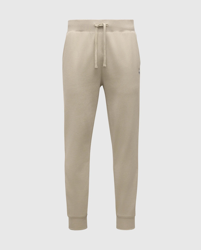 The MENS LEVY ESSENTIAL FLEECE SWEATPANTS - B6P721D200 by Psycho Bunny are beige sweatpants made from ultra-soft cotton fleece, featuring an elastic waistband with a drawstring, side pockets, and ribbed ankle cuffs against a plain white background.