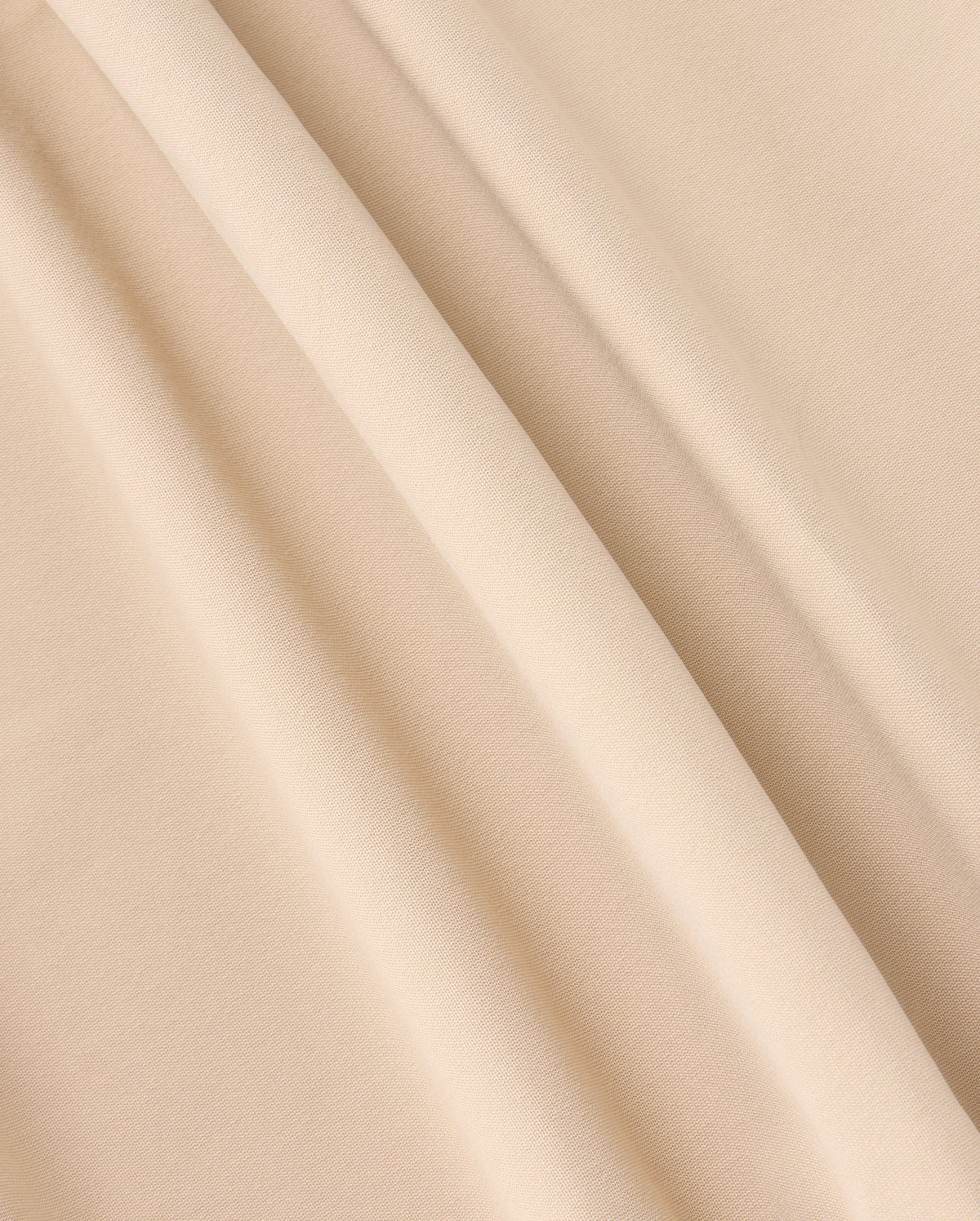 A close-up photograph of beige-colored fabric with a soft, smooth texture. The fabric, similar to that of the Psycho Bunny Mens Maverick 10K Pant (B6P788D200), is draped in gentle folds, creating light and shadow variations across its surface.