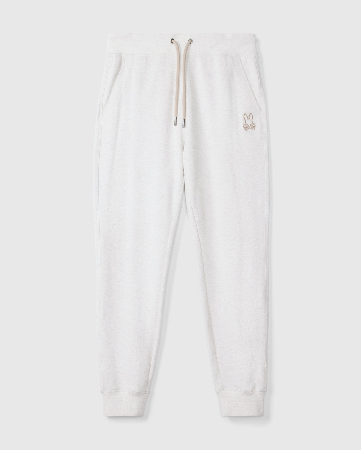 The MENS JAMES PREMIUM SWEATPANT - B6P791D200 by Psycho Bunny delivers ultimate comfort with its light gray cotton-blend fabric, featuring an elastic waistband, drawstring, and side pockets. A small rabbit logo is elegantly embroidered on the upper left side. These sweatpants have ribbed cuffs and are presented flat against a plain background.