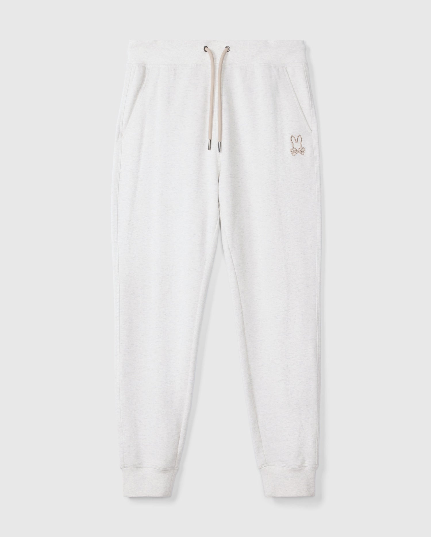 The MENS JAMES PREMIUM SWEATPANT - B6P791D200 by Psycho Bunny delivers ultimate comfort with its light gray cotton-blend fabric, featuring an elastic waistband, drawstring, and side pockets. A small rabbit logo is elegantly embroidered on the upper left side. These sweatpants have ribbed cuffs and are presented flat against a plain background.