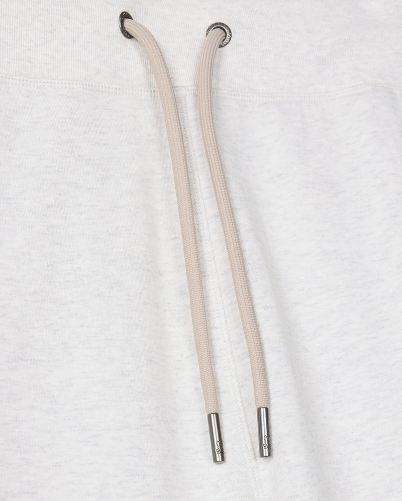 Close-up of the Psycho Bunny MENS JAMES PREMIUM SWEATPANT - B6P791D200 in a light gray cotton-blend, featuring beige drawstrings with metal tips nestled against the plush fabric. The texture is prominently visible, while the drawstring holes are reinforced with metal eyelets, perfectly embodying both style and comfort.