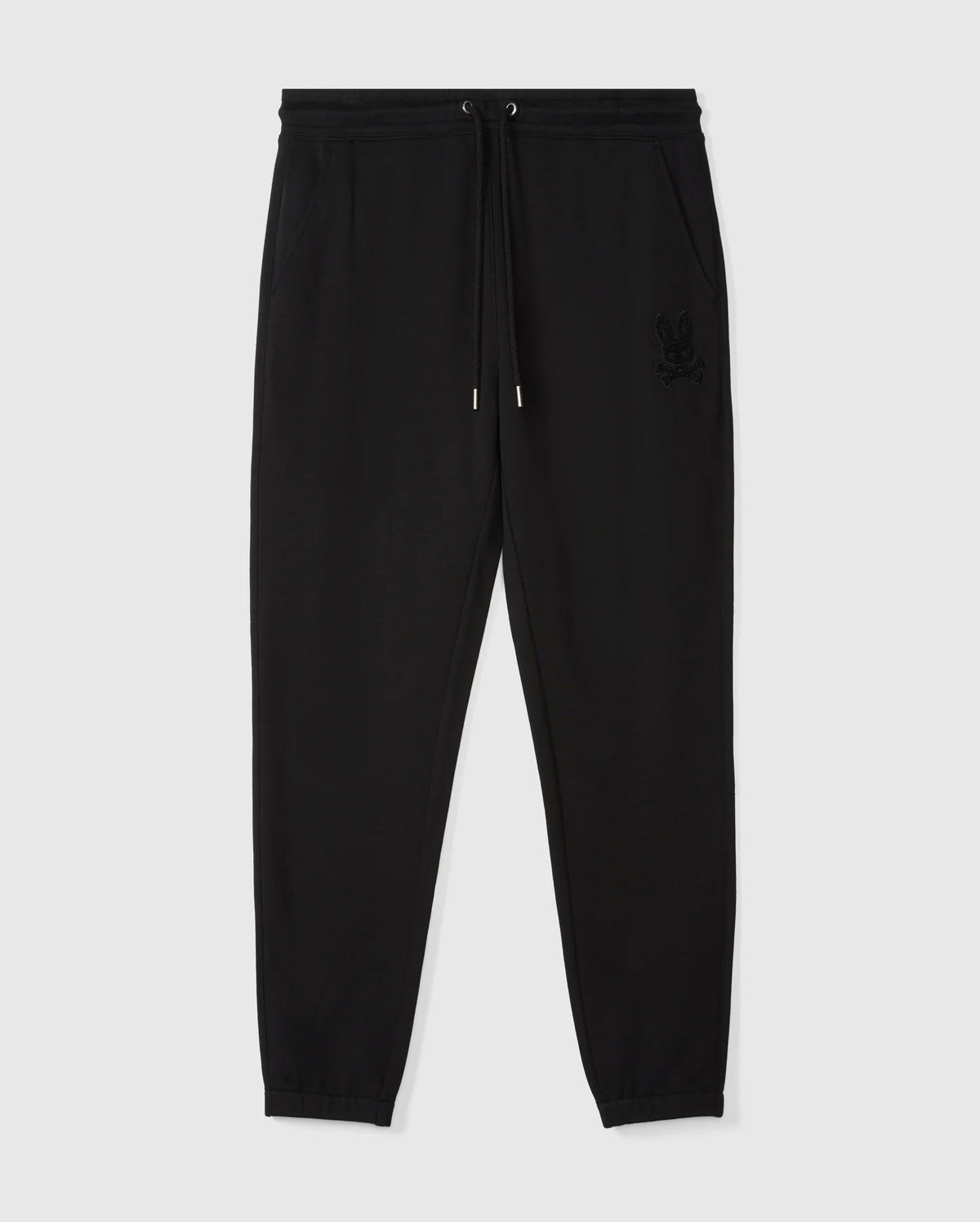 Introducing the MENS PACIFIC CHENILLE JOGGER - B6P972D200 by Psycho Bunny: a sleek pair of black jogger pants designed with an elastic waistband, drawstring, and cuffs. These casual bottoms are adorned with an embroidered logo on the left hip for added style. They are stylishly presented against a light gray backdrop.